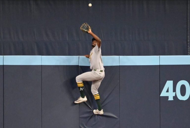 Watch: A’s outfielder scales wall to rob a home run